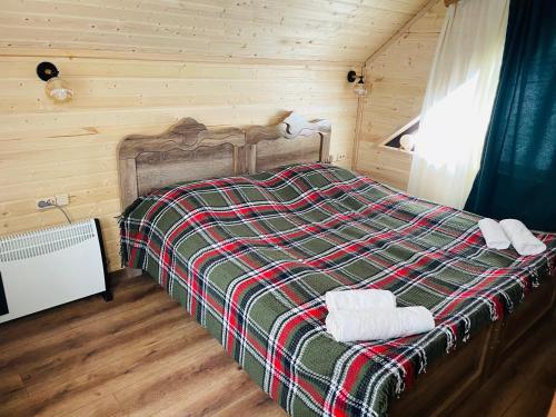 1 dormitorio con 1 cama con 2 toallas en Cottage Am Museum, en Mestia