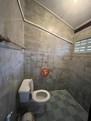 a small bathroom with a toilet and a tile floor at Revolution Pai In Town in Pai