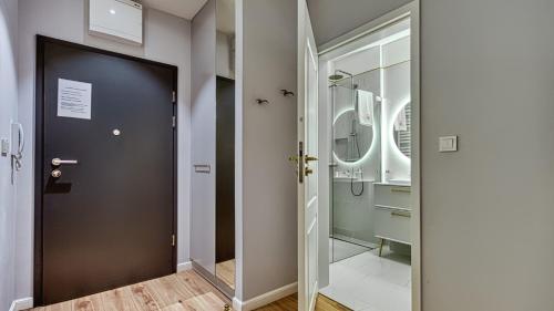 a bathroom with a black door and a walk in shower at Rezydencja Niechorze 113 - 5D Apartamenty in Niechorze