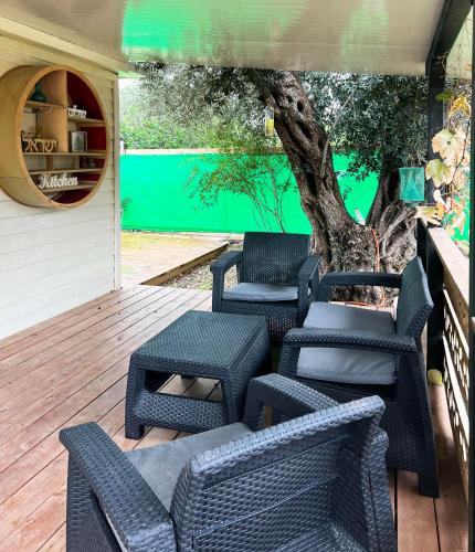 a group of chairs and a tree on a deck at Jordan River Village in Menaẖemya