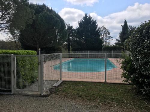 une clôture autour d'une piscine dans une cour dans l'établissement Gîte de Sauvagnac, à Cavagnac