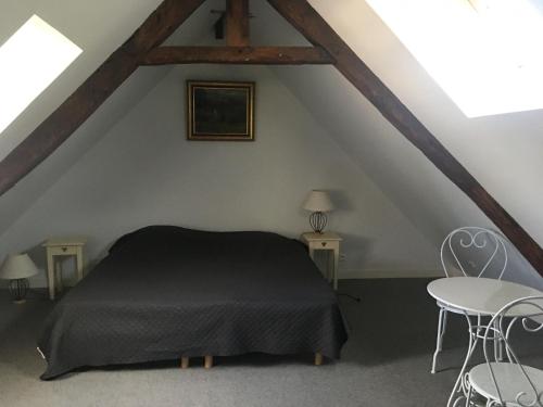 - une chambre mansardée avec un lit noir dans l'établissement Gîte de Sauvagnac, à Cavagnac