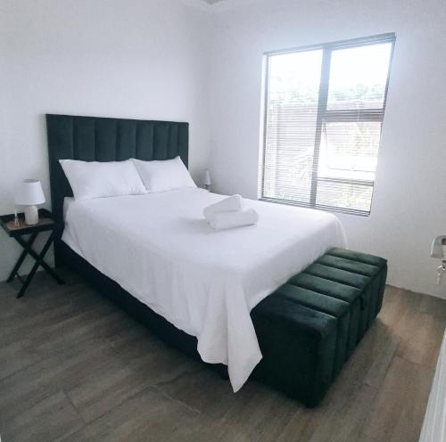 een slaapkamer met een groot wit bed en een raam bij Bakoena's full house in Newcastle