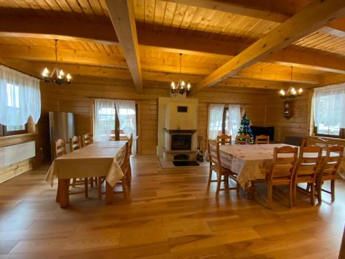 uma sala de jantar com pisos em madeira e uma mesa e cadeiras em Nowica 71 Dom Jodłowy em Nowica