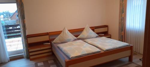 a bedroom with a bed with two pillows on it at Ferienwohnung Aue Deußen in Erftstadt