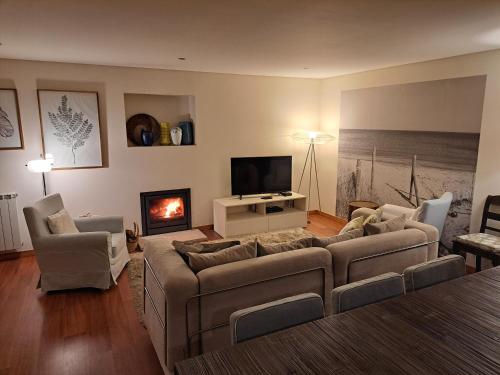 - un salon avec un canapé et une télévision dans l'établissement Casa Santana, à Moledo