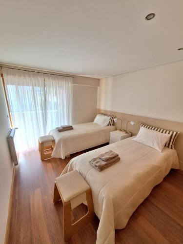 a hotel room with two beds and a window at Casa Santana in Moledo