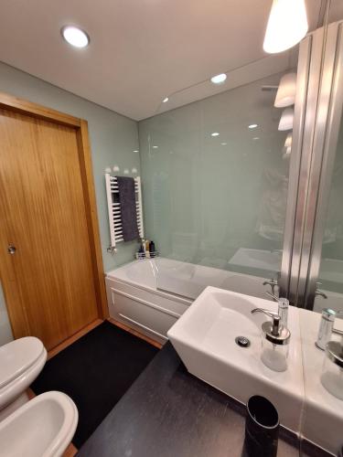 a bathroom with a sink and a tub and a toilet at Casa Santana in Moledo