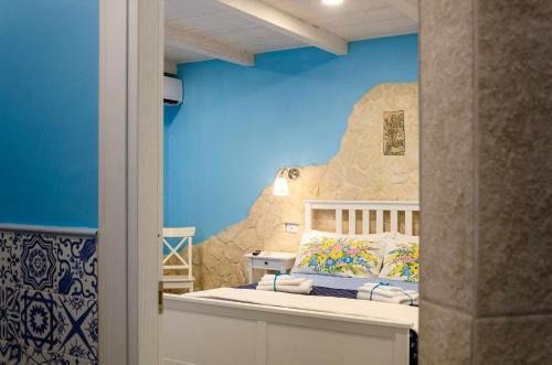ein Schlafzimmer mit einem Bett mit einer Felswand in der Unterkunft Casa della Perla in Giarre