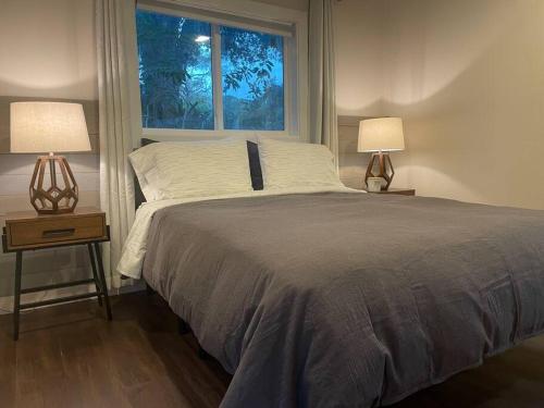 ein Schlafzimmer mit einem Bett mit zwei Lampen und einem Fenster in der Unterkunft Shares Courtyard Luxury Apt - NEW! in Rockledge