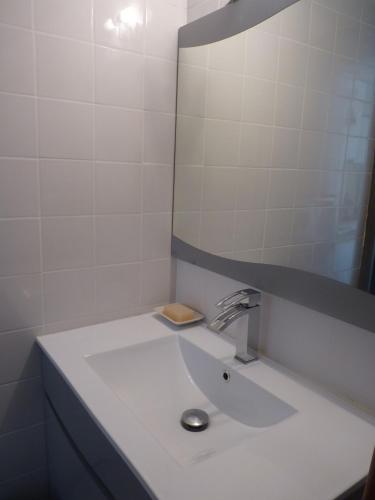 une salle de bain blanche avec un lavabo et un miroir dans l'établissement Coquet Pavillon T2 mezzanine, Les Feulouques, Saint Pierre la Mer, à Saint Pierre La Mer