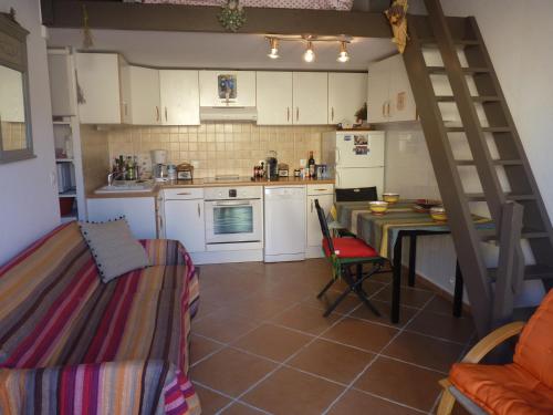 - une cuisine avec une table et une échelle dans une pièce dans l'établissement Coquet Pavillon T2 mezzanine, Les Feulouques, Saint Pierre la Mer, à Saint Pierre La Mer