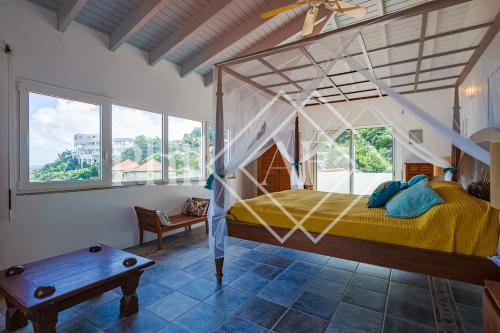 ein Schlafzimmer mit einem Himmelbett und einem Tisch in der Unterkunft 6 bed-rooms Villa at Dawn Beach Estate in Dawn Beach