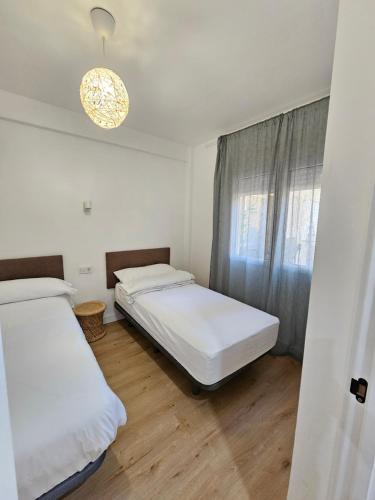 2 camas en una habitación con ventana en Exclusivo apartamento cerca de la playa, en Málaga