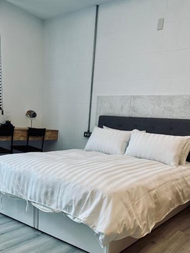 - une chambre avec un grand lit et des draps blancs dans l'établissement Inside the alley, à Tainan