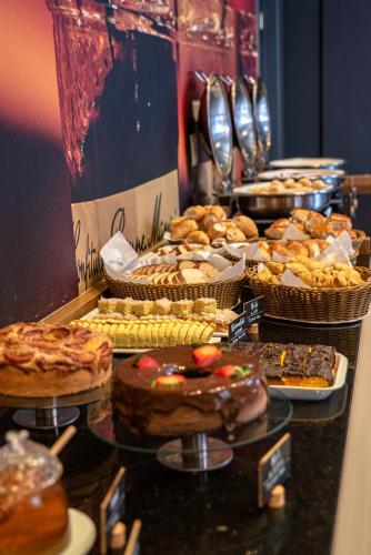 a buffet with many different types of pastries and desserts at Ibis Guaratingueta Aparecida - Circuito da Fé in Guaratinguetá