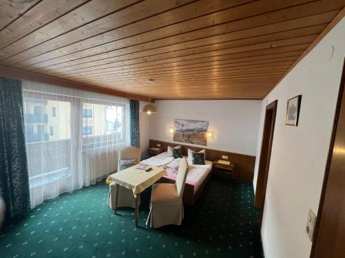 Habitación de hotel con cama y mesa en Pension Aloisl`s Harmonie, en Nauders