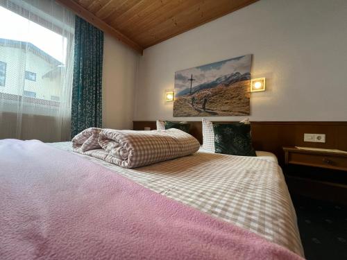 a bedroom with a large bed and a window at Pension Aloisl`s Harmonie in Nauders