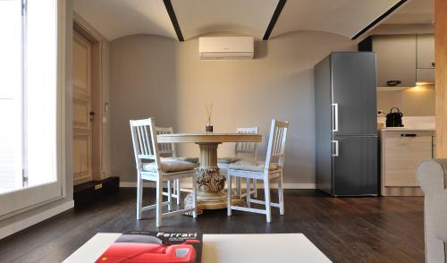 a kitchen with a table and chairs and a refrigerator at Eulalia's House in Modena