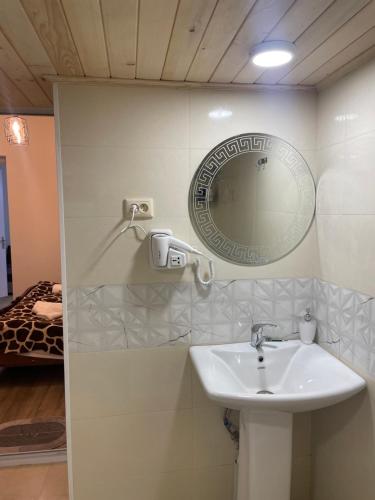 a bathroom with a sink and a mirror on the wall at Mamuka Chartolani Guesthouse in Mestia