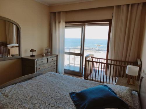 a bedroom with a bed and a view of the ocean at Ocean View in Vila do Conde