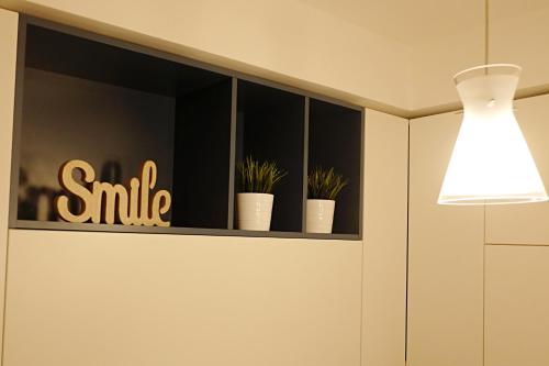 a shelf with plants and a light on it at Orea Spiti - Modern Oasis Near Milan in Assago