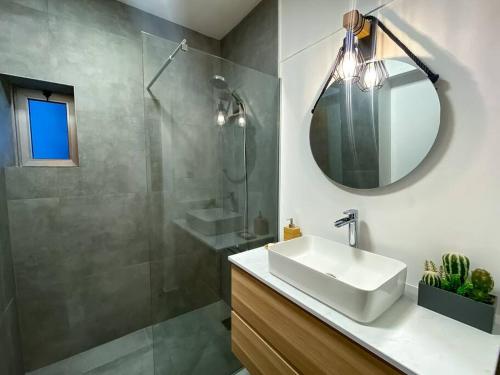a bathroom with a sink and a shower and a mirror at Ocean View in Vila do Conde