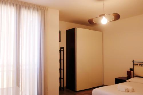 a bedroom with a black and white cabinet next to a window at Orea Spiti - Modern Oasis Near Milan in Assago