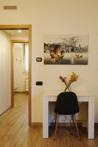 a white table with a black chair in a room at Orea Spiti - Modern Oasis Near Milan in Assago