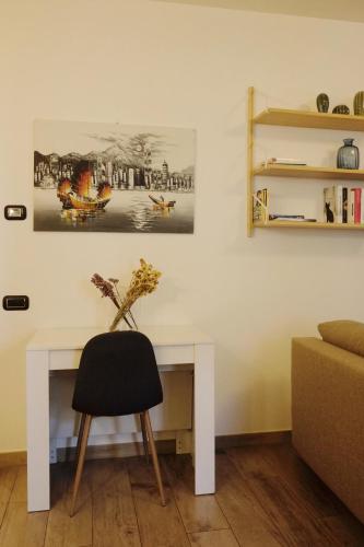 a white desk with a chair and a vase of flowers at Orea Spiti - Modern Oasis Near Milan in Assago