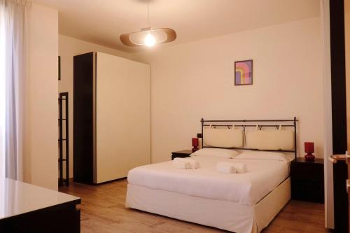 - une chambre avec un grand lit blanc et 2 serviettes dans l'établissement Orea Spiti - Modern Oasis Near Milan, à Assago