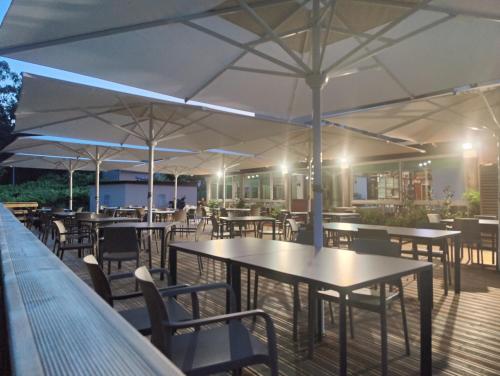 an outdoor patio with tables and chairs and umbrellas at El Retiro in Nigrán