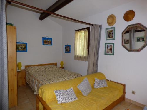 - une chambre avec deux lits et un canapé jaune dans l'établissement Pavillon Studio Mezzanine, Les Patios de la Plage, Saint Pierre la Mer, à Saint Pierre La Mer