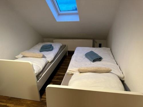 two beds in a small room with a window at Ferienwohnung Jule in Wernigerode