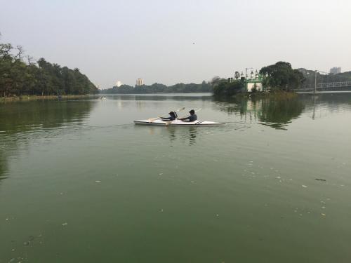 two people on a paddle board in the water at A Cosy (Greek Style) Den in Kolkata