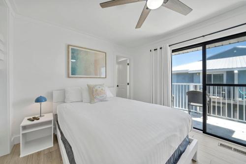 a white bedroom with a bed and a large window at Laguna Point #6 Holiday Isle Free Activities in Destin