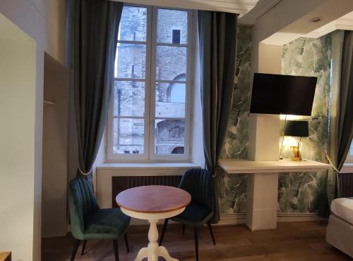 a living room with a table and chairs and a window at Le Pavillon Saint-Martin in Souillac