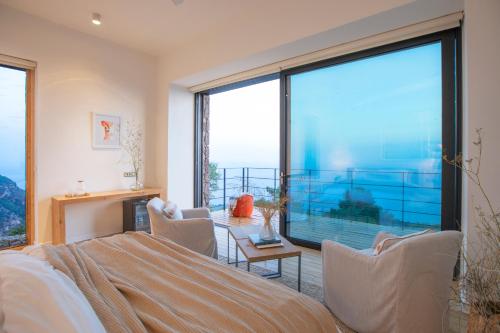 a bedroom with a bed and a large window at Momos Otel in Ayvacık
