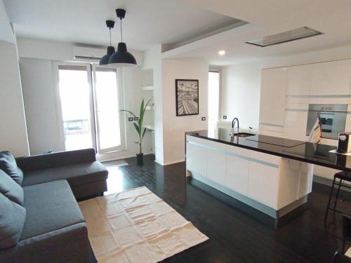 uma cozinha e sala de estar com um sofá e um balcão em FrenzHouse - Terraced Apartment close to Rho Fiera and San Siro em Baranzate