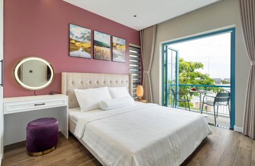 Schlafzimmer mit einem Bett mit einem Spiegel und einem Balkon in der Unterkunft Novaworld Phan Thiết - Đông Phương Villa in Bình Tú