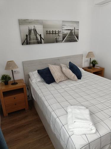 a bed with two pillows on it in a room at Apartamento con VISTAS AL MAR in Oliva