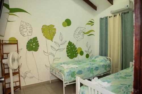 a bedroom with a wall mural of leaves at Apartamento Costa luna in Jacó