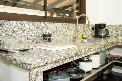 a kitchen counter with a sink and some pots and pans at Apartamento Costa luna in Jacó