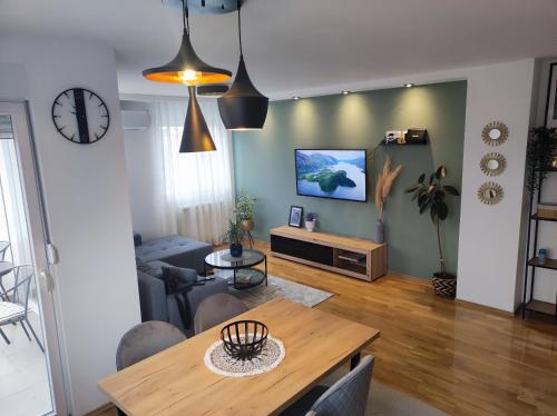 a living room with a table and a tv at Riverside LUX Apartment in Pirot