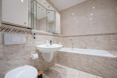 a bathroom with a sink and a toilet and a tub at Suite mit Moselblick in Traben-Trarbach