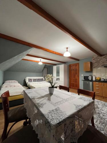 a room with a table and a bed and a kitchen at Pokoje u Pawloka in Ciche