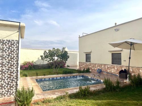 una piscina in un cortile accanto a un edificio di Amazing Home in Agafay area a Marrakech