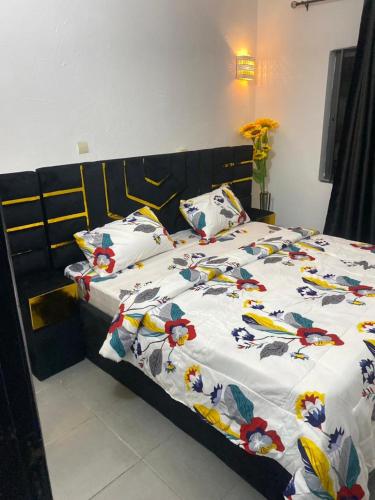 a bed with a white comforter and pillows on it at Charly-chic@ in Cotonou