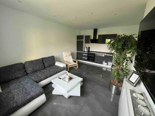 a living room with a couch and a table at Schönes 2 Zimmer Apartment an der Stadt Grenze in Blankenfelde