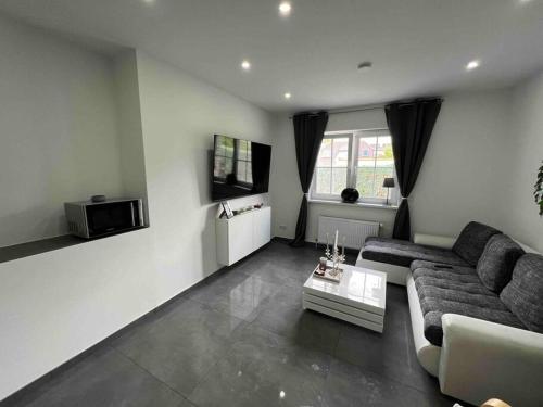 a living room with a couch and a tv at Schönes 2 Zimmer Apartment an der Stadt Grenze in Blankenfelde